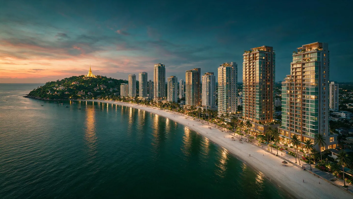 เมืองริมทะเลรูปอ่าวโค้งยามพลบ มีคอนโดสูงเรียงตามแนวชายหาดและถนนเลียบหาดที่มีต้นปาล์ม